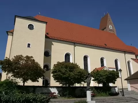 Gebetshaus mit Kirchturm, drei Bäume neben Steintreppe