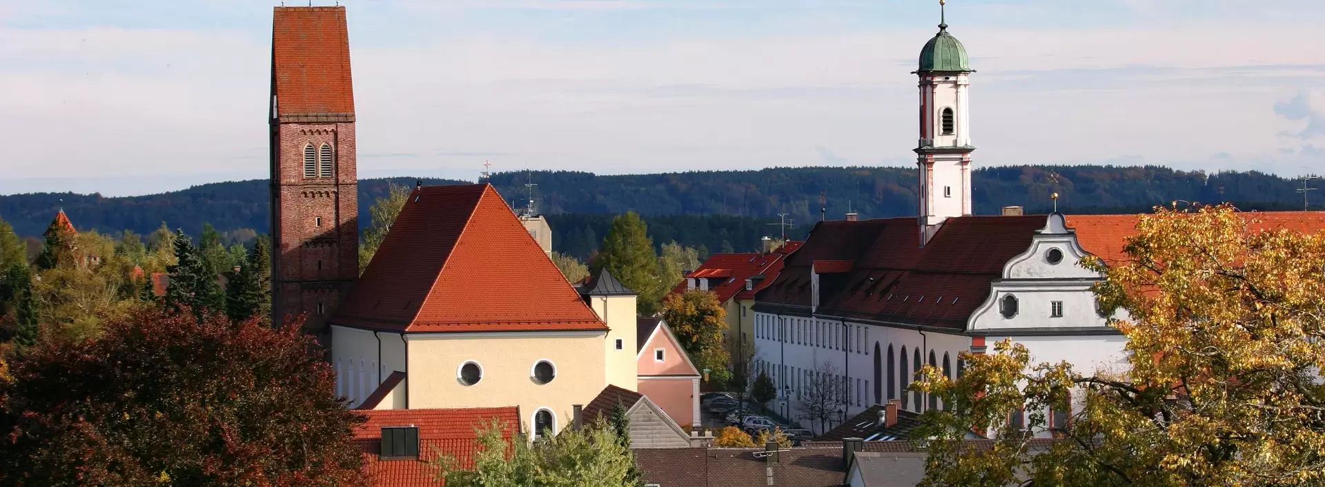 Panoramabild von Bad Wörishofen, mit Kloster und Kirche im Blick, Bäume und blauer Himmel