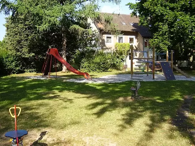 Spielplatz, Schaukeltiere, rote Rutsche, Kletterturm, mit Wackelleiter, Kletterbrett, Netz