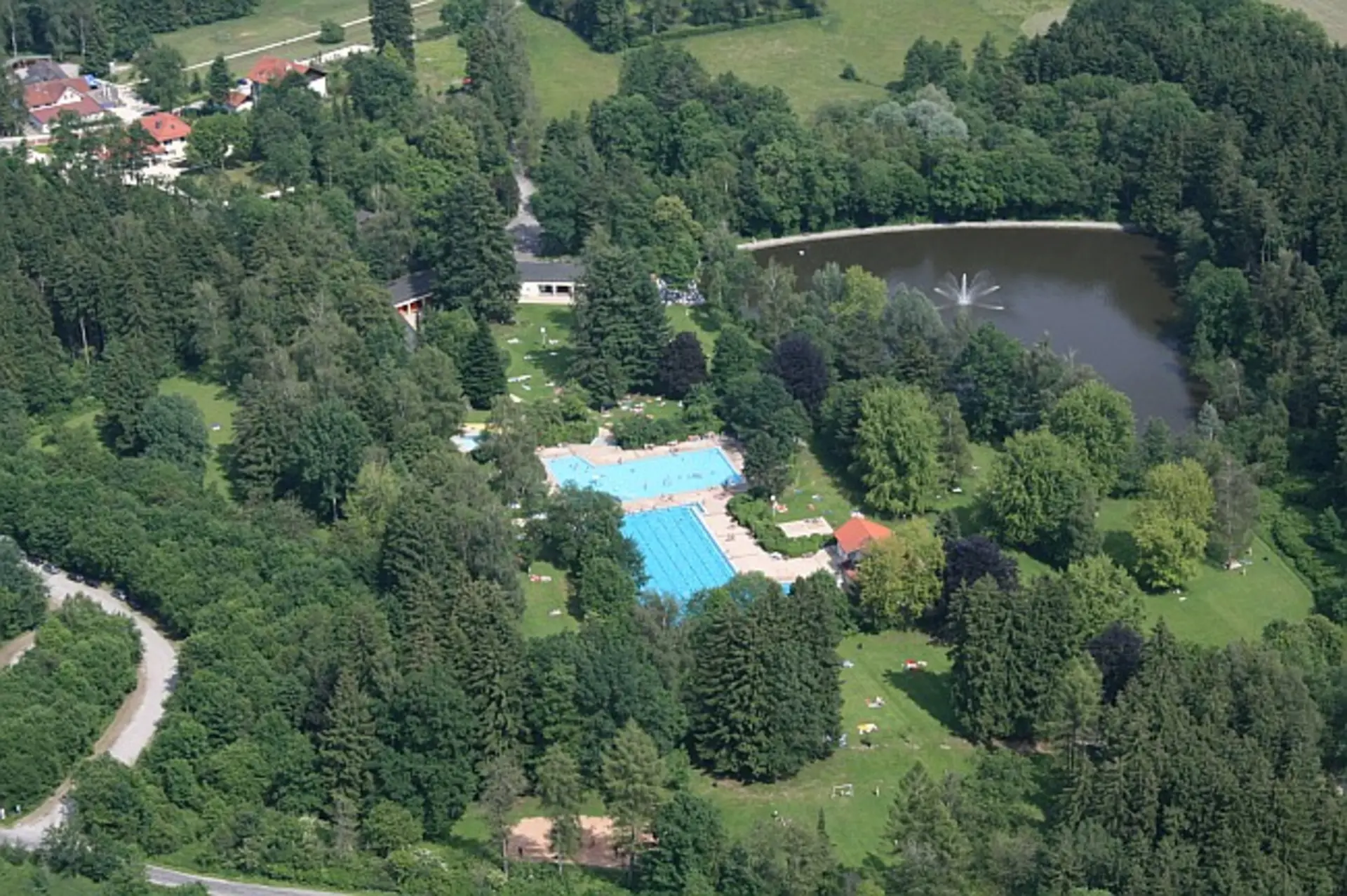 Freibad von oben, ringsherum grüne Bäume