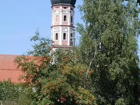 alter Kirchturm hinterhalb von Bäumen