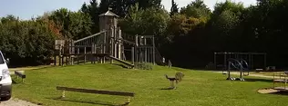 großer hölzender Kletterturm mit Schwebebalken, Hangelbalken. Schaukeltieren